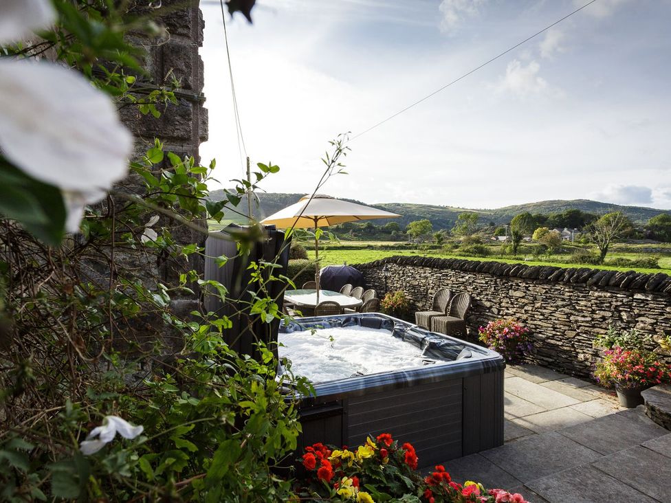 A garden with a hot tub and seating area at Grove House in Grange-Over-Sands