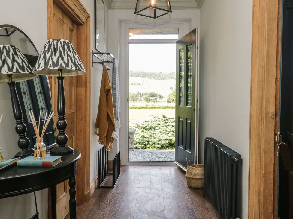 A hallway with a table and lamp at Grove House in Grange-Over-Sands