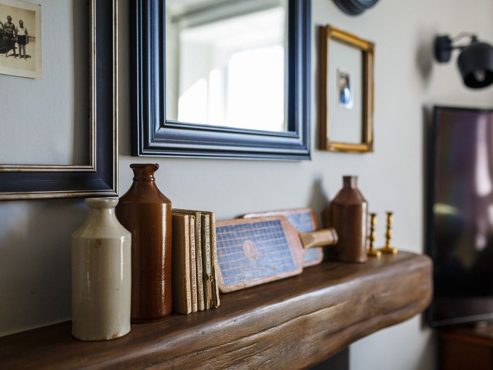 A living room with decor including vases and books at Grove House in Grange-Over-Sands