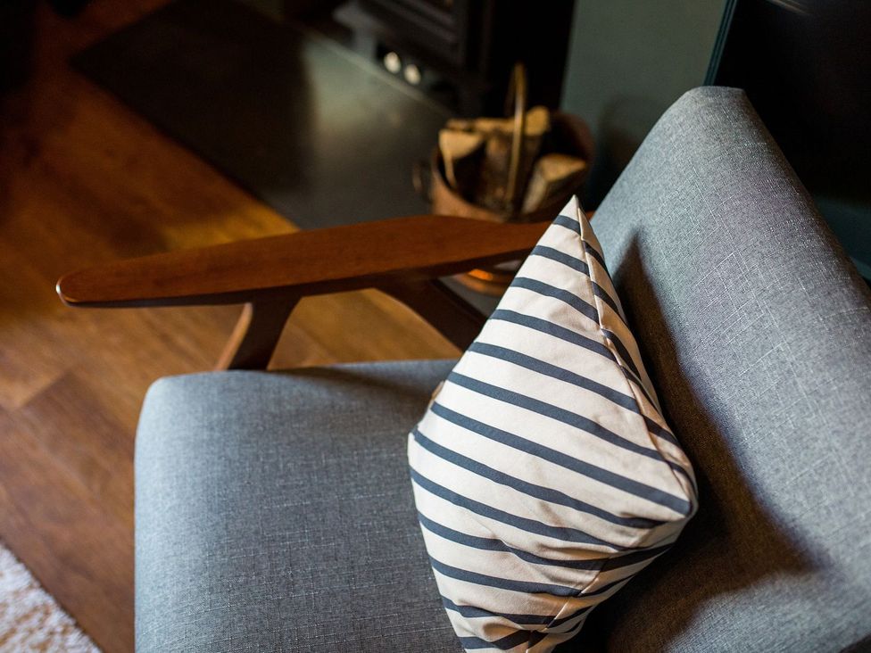 A chair with a pillow in a living room at Grove House in Grange-Over-Sands