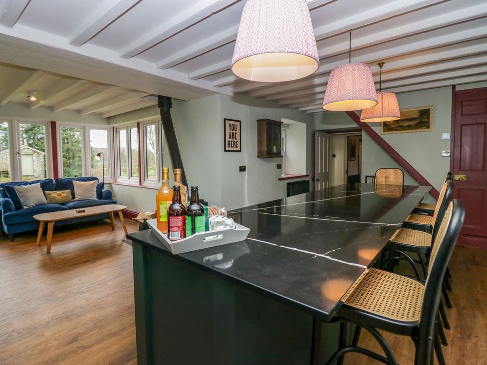 A kitchen with a bar area and seating at Grove House in Grange-Over-Sands
