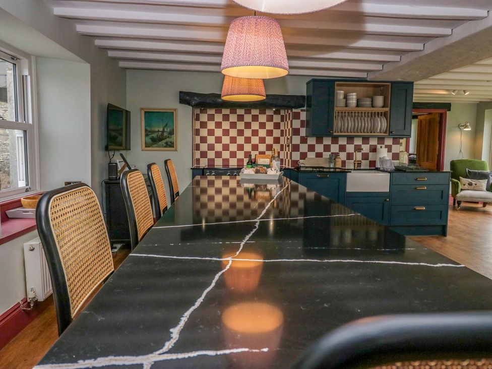 A kitchen with a large island and seating at Grove House in Grange-Over-Sands