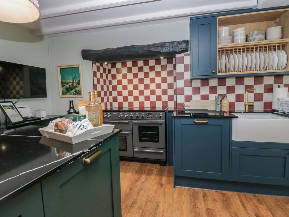 A kitchen with oven, sink, and countertop at Grove House in Grange-Over-Sands
