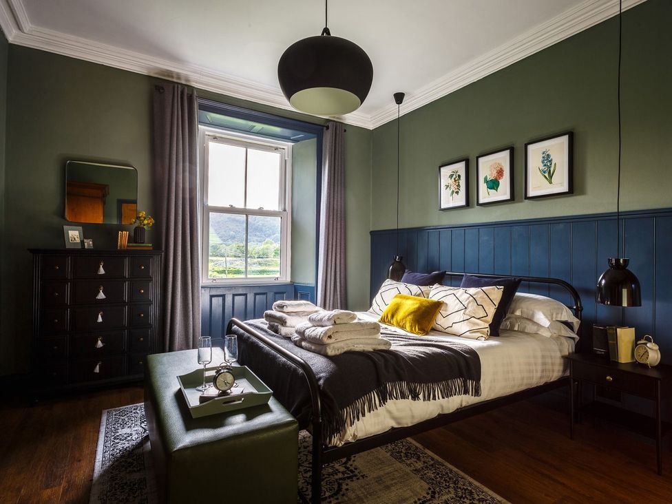 A bedroom with a bed and a dresser at Grove House in Grange-Over-Sands