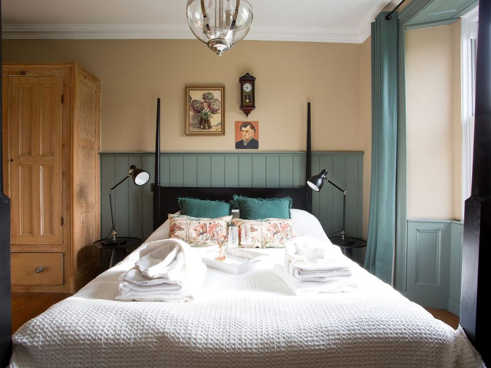 A bedroom with a bed and wardrobe at Grove House in Grange-Over-Sands