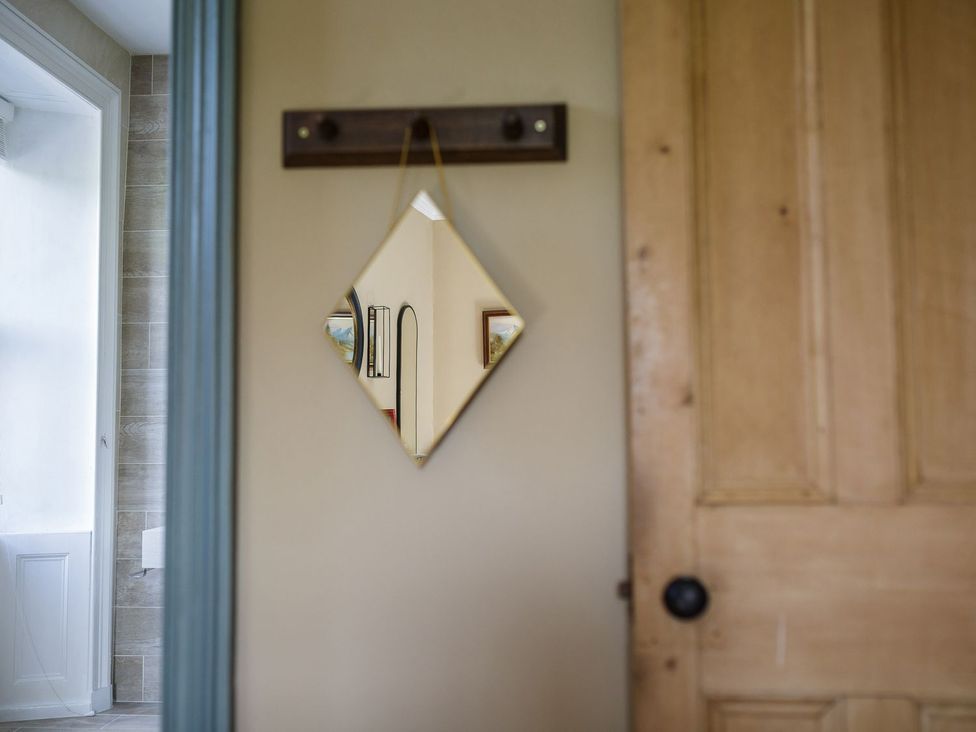 A mirror and a door in a hallway at Grove House in Grange-Over-Sands