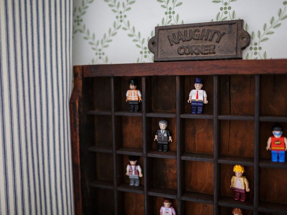 A wooden display with figurines under a sign at Grove House in Grange-Over-Sands