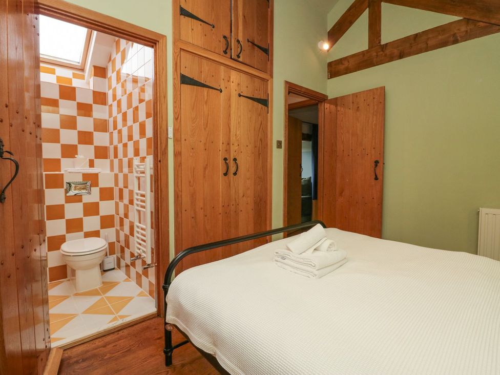 A bedroom with a bed and bathroom entrance at Grove House in Grange-Over-Sands