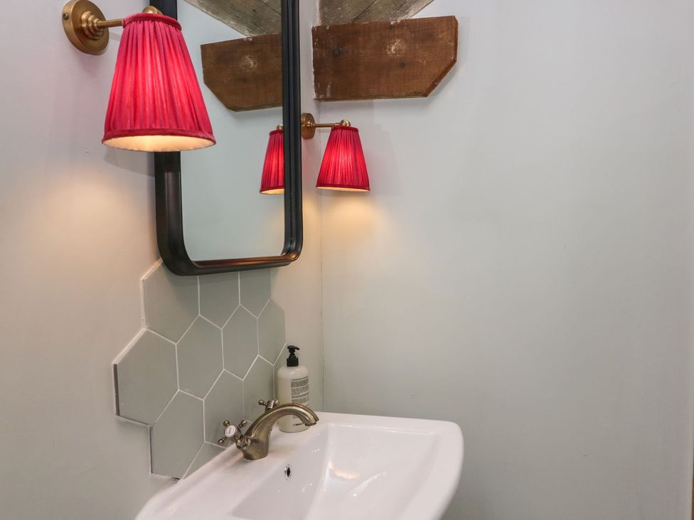 A bathroom with sink and mirror at Grove House in Grange-Over-Sands