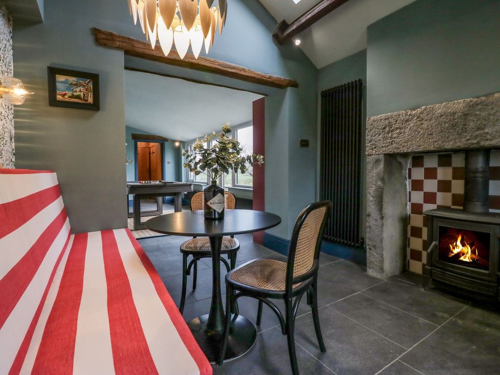 A cozy snug with seating and a fireplace at Grove House in Grange-Over-Sands