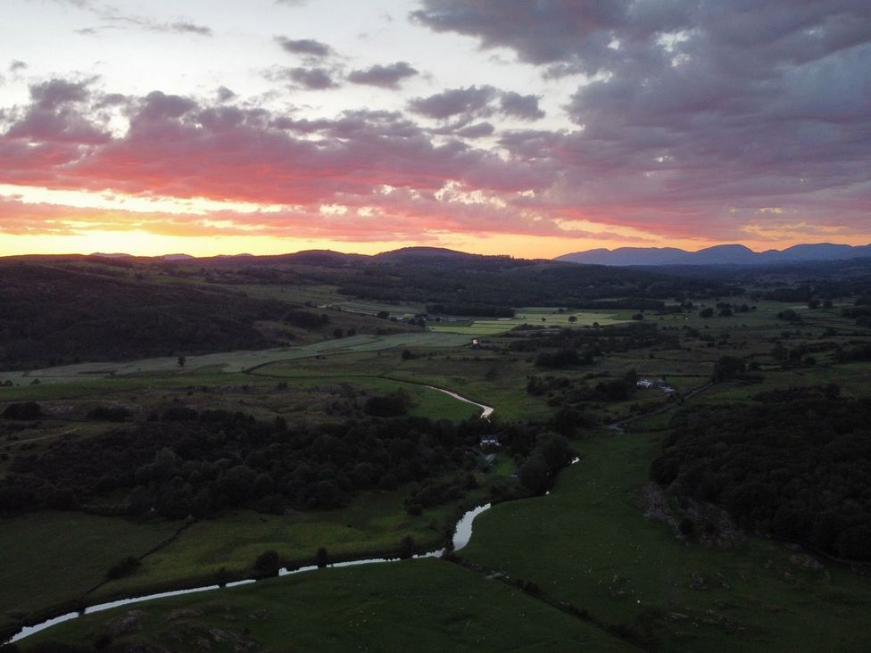 A scenic landscape with a sunset over fields and mountains at Grove House in Grange-Over-Sands