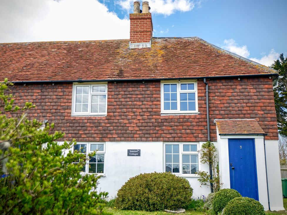 A house with a blue door and windows at Seaview Cottages in Normans Bay near Bexhill-on-Sea
