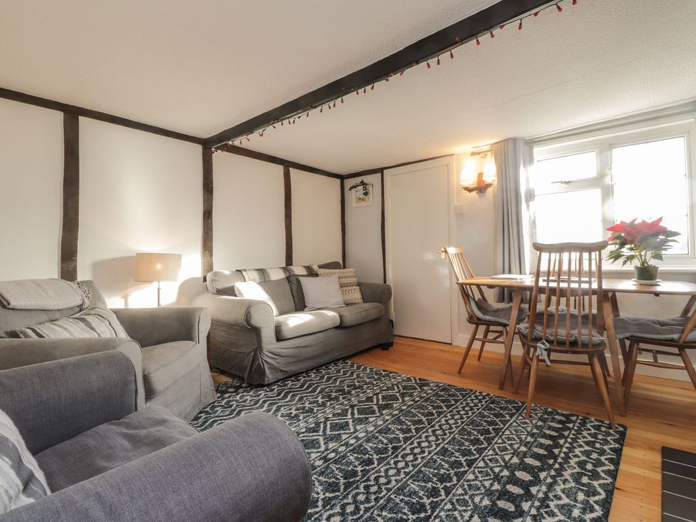 A living room with a sofa and dining table at 3 Seaview Cottages in Normans Bay near Bexhill-on-Sea