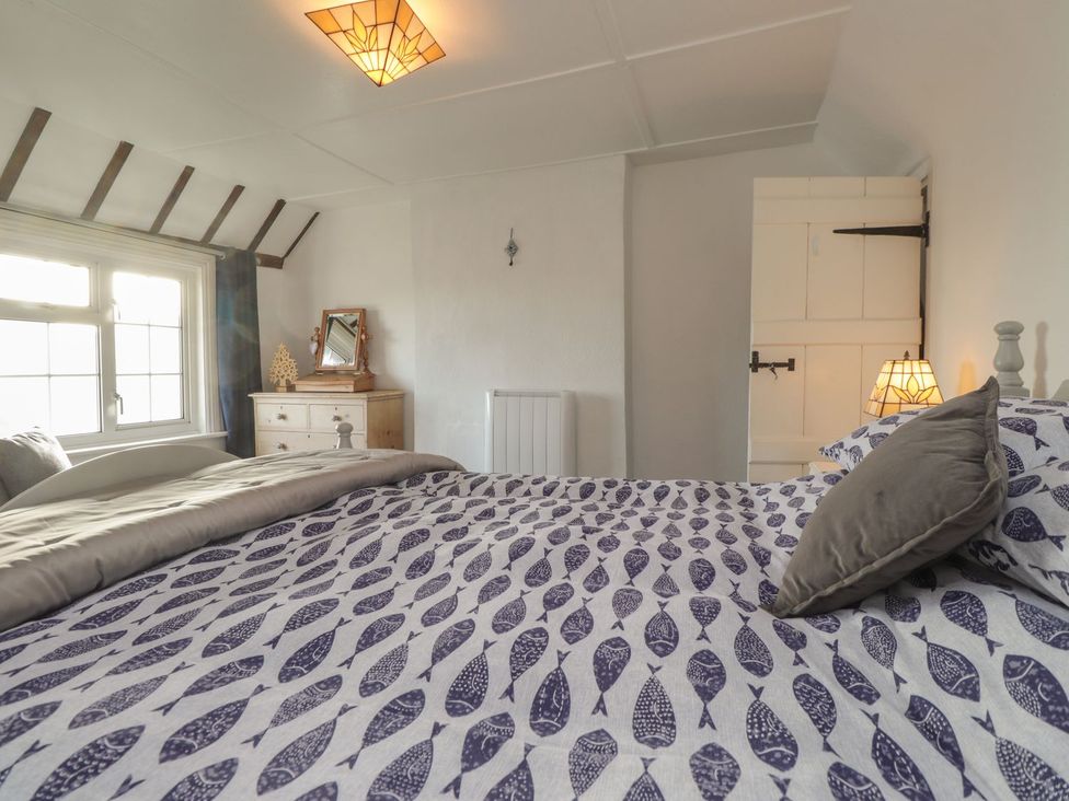 A bedroom with a bed and dresser at 3 Seaview Cottages Normans Bay near Bexhill-on-Sea