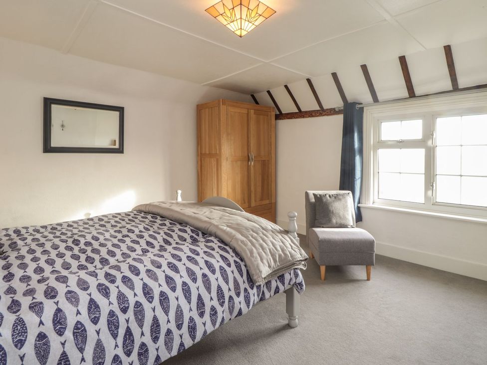 A bedroom with a bed and wardrobe at 3 Seaview Cottages Normans Bay near Bexhill-on-Sea