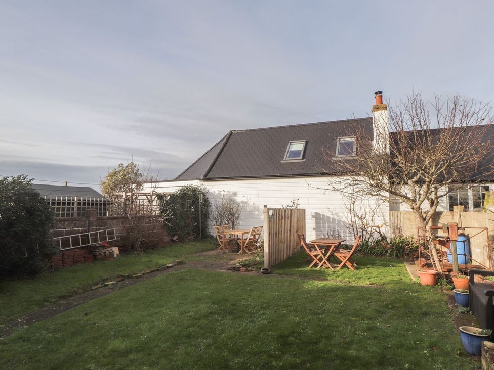 A garden with a table and chairs at 3 Seaview Cottages Normans Bay near Bexhill-on-Sea