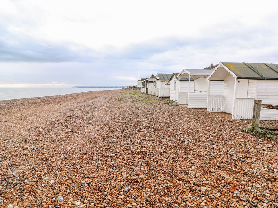 A row of beach huts along a pebbled beach at 3 Seaview Cottages Normans Bay near Bexhill-on-Sea