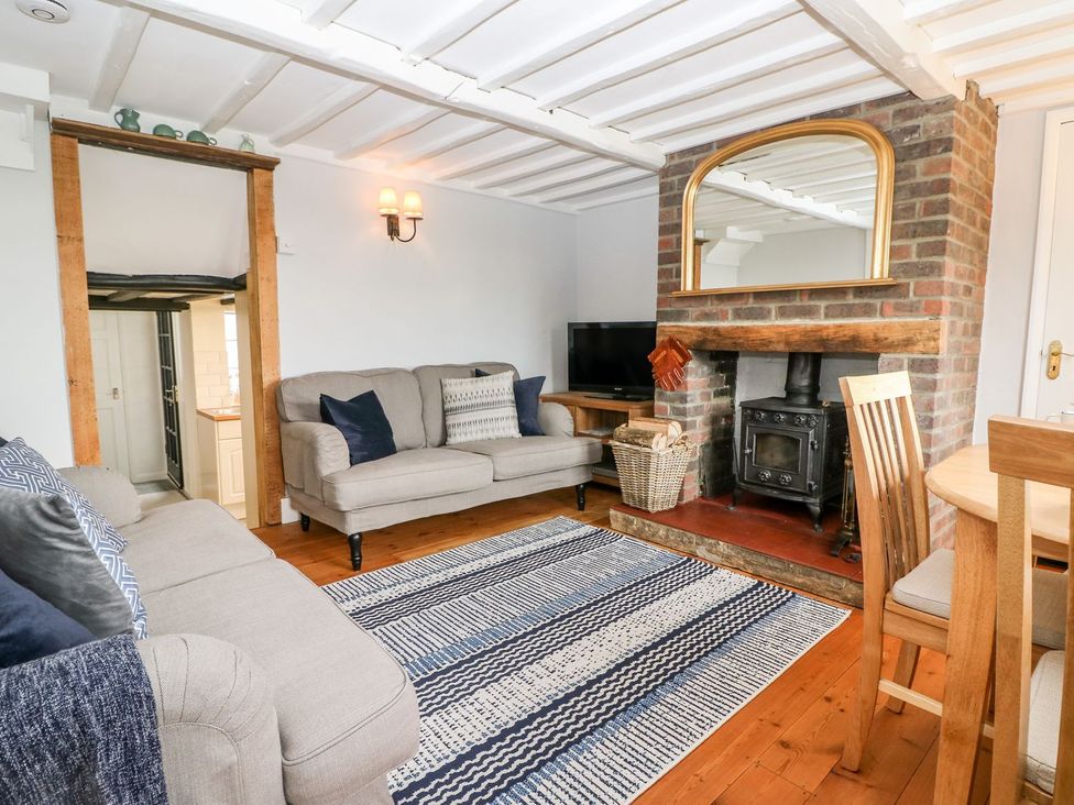 A living room with a sofa and television at 2 Seaview Cottages Normans Bay near Bexhill-On-Sea