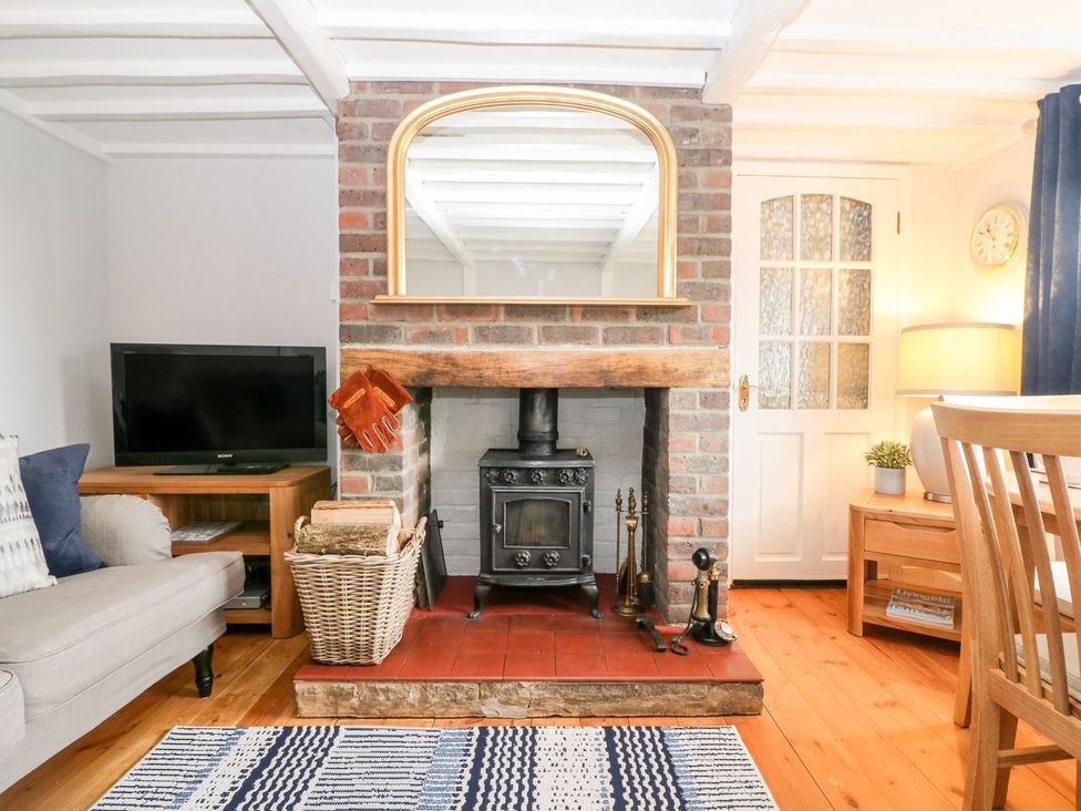 A living room with a fireplace and television at 2 Seaview Cottages in Normans Bay near Bexhill-On-Sea