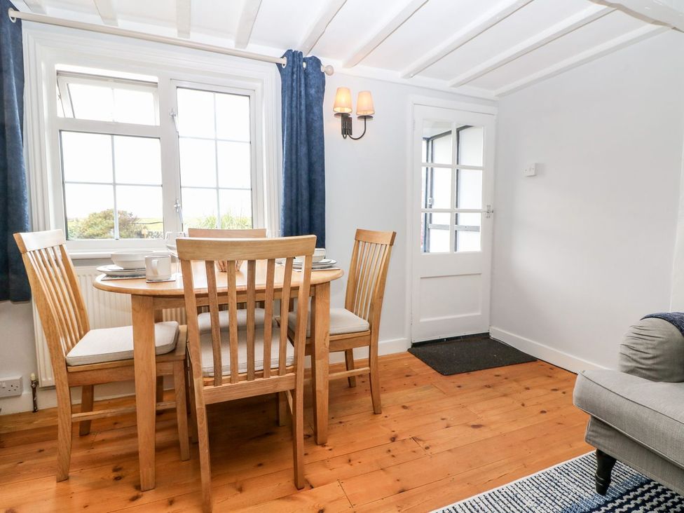 A dining room with a table and chairs at 2 Seaview Cottages Normans Bay near Bexhill-On-Sea