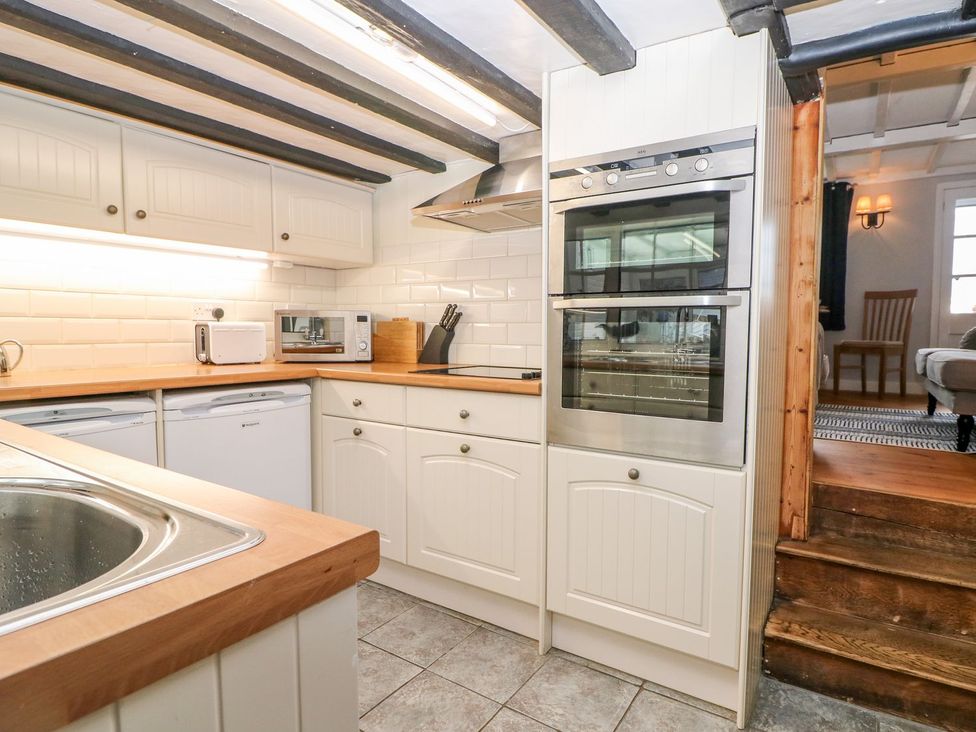 A kitchen with sink, oven, microwave and dishwasher at 2 Seaview Cottages Normans Bay near Bexhill-On-Sea