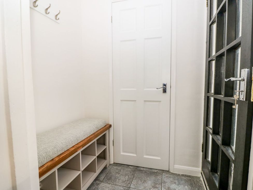 A hallway with a bench and hooks at 2 Seaview Cottages Normans Bay near Bexhill-On-Sea