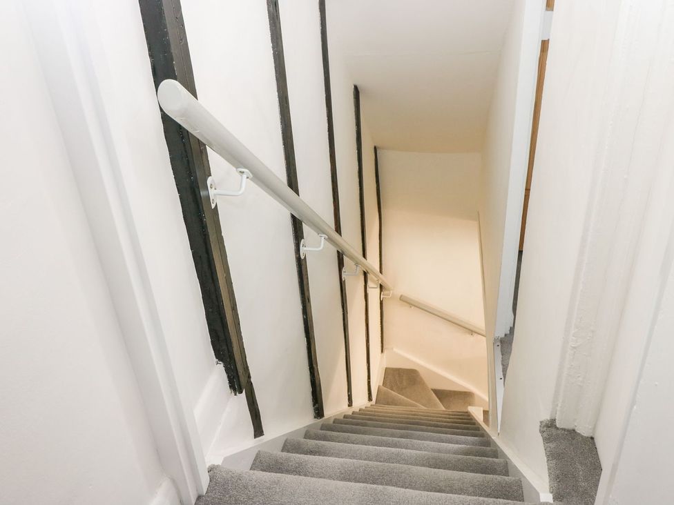 A staircase with handrail and carpet at 2 Seaview Cottages Normans Bay near Bexhill-On-Sea
