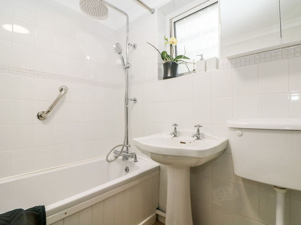 A bathroom with a shower and bathtub at 2 Seaview Cottages Normans Bay near Bexhill-On-Sea