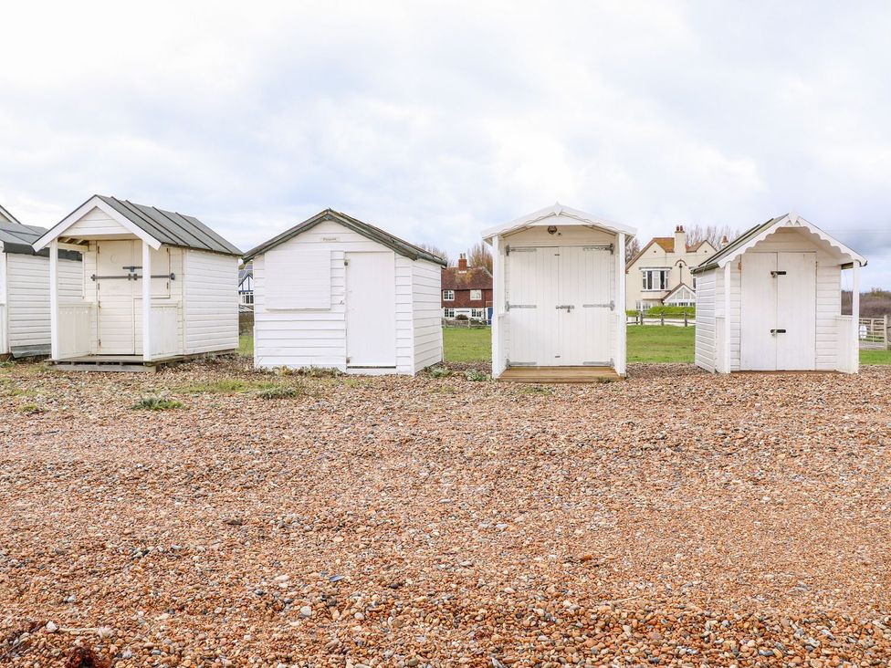 Beach huts on gravel at 2 Seaview Cottages in Normans Bay near Bexhill-On-Sea