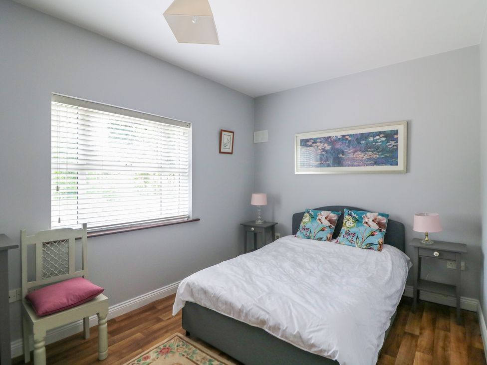 A bedroom with a bed and bedside tables at The Lodge in Gorey, County Wexford