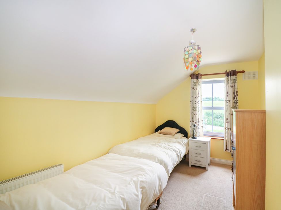 A bedroom with two beds and a window at The Lodge in Gorey, County Wexford