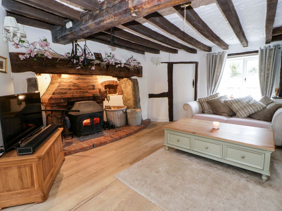A living room with a fireplace and a television at The Old Shop in Builth Wells