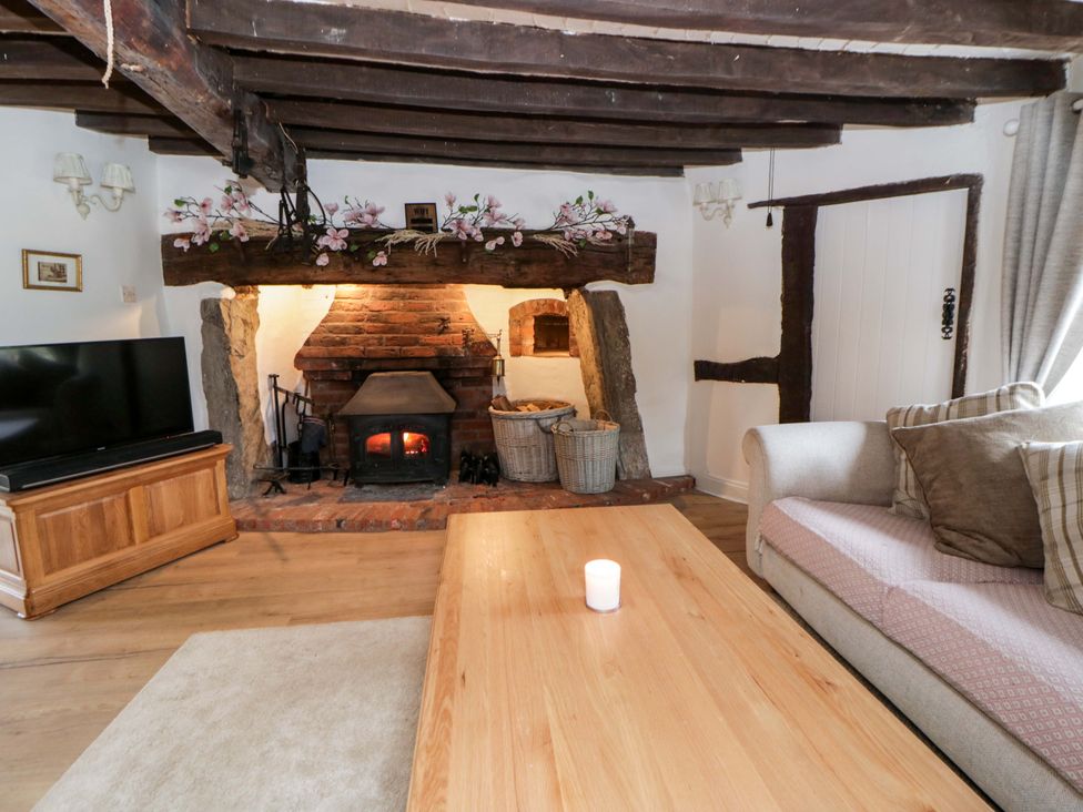 A living room with a fireplace, sofa, and tv at The Old Shop in Builth Wells