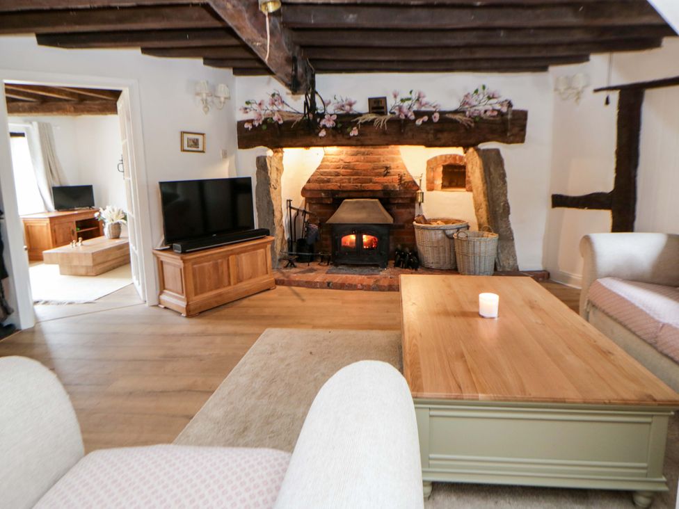 A living room with a fireplace and television at The Old Shop in Builth Wells