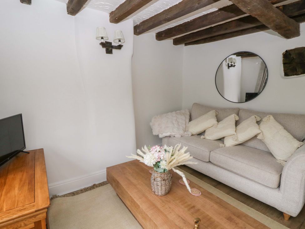 A snug with a sofa and television at The Old Shop in Builth Wells