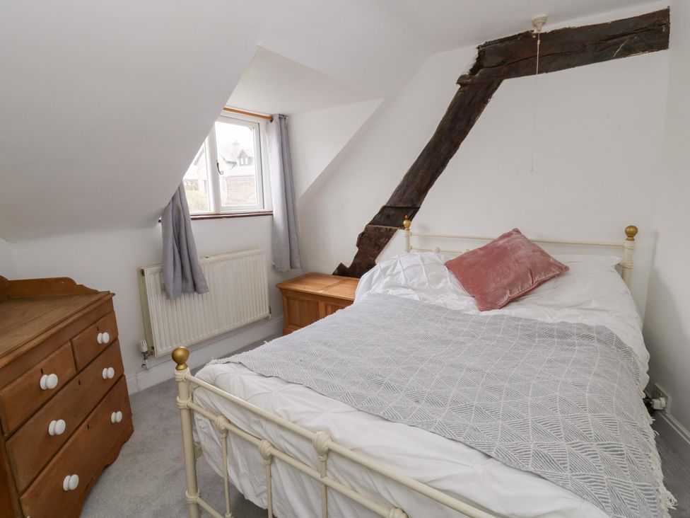A bedroom with a bed, chest of drawers and a window at The Old Shop in Builth Wells