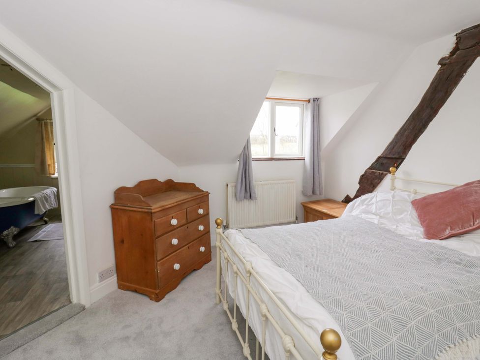 A bedroom with a bed and a dresser at The Old Shop in Builth Wells