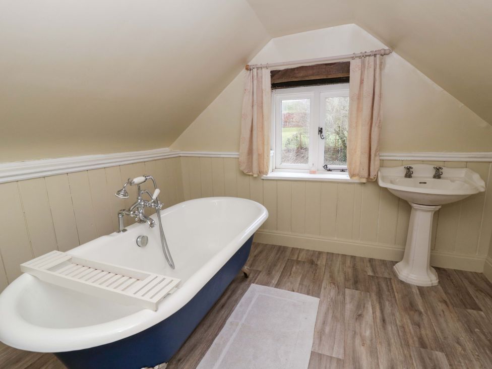 A bathroom with a bathtub and a sink at The Old Shop in Builth Wells