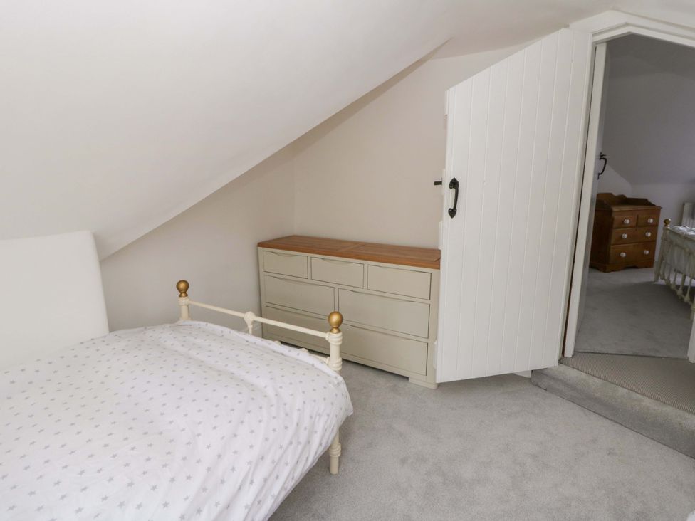 A bedroom with a bed and a dresser at The Old Shop in Builth Wells