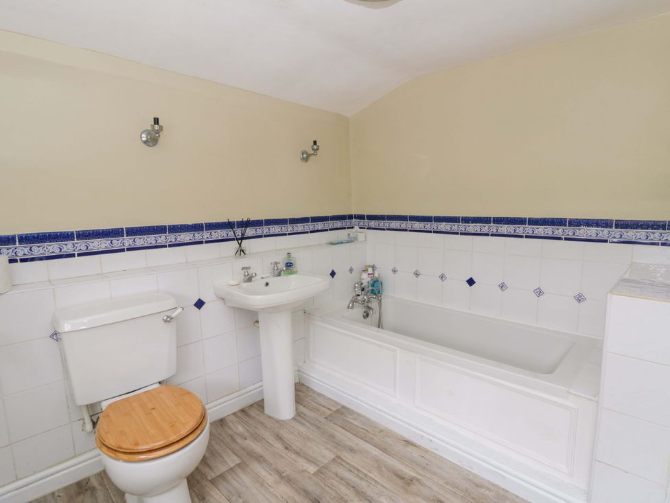 A bathroom with a toilet, sink, and bathtub at The Old Shop in Builth Wells