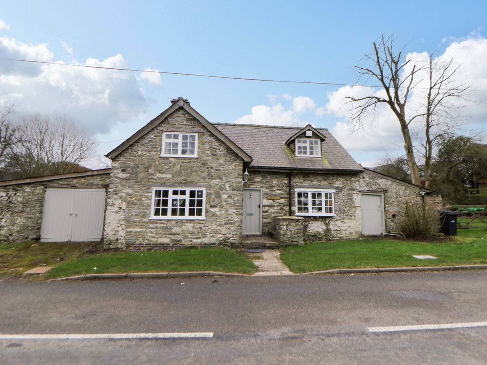 A stone house with a garage at The Old Shop in Builth Wells