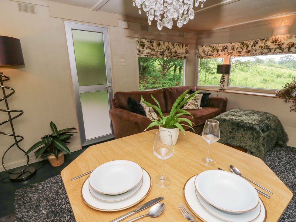 A living room with a table set for dining at Gwybedog in Llanwrda