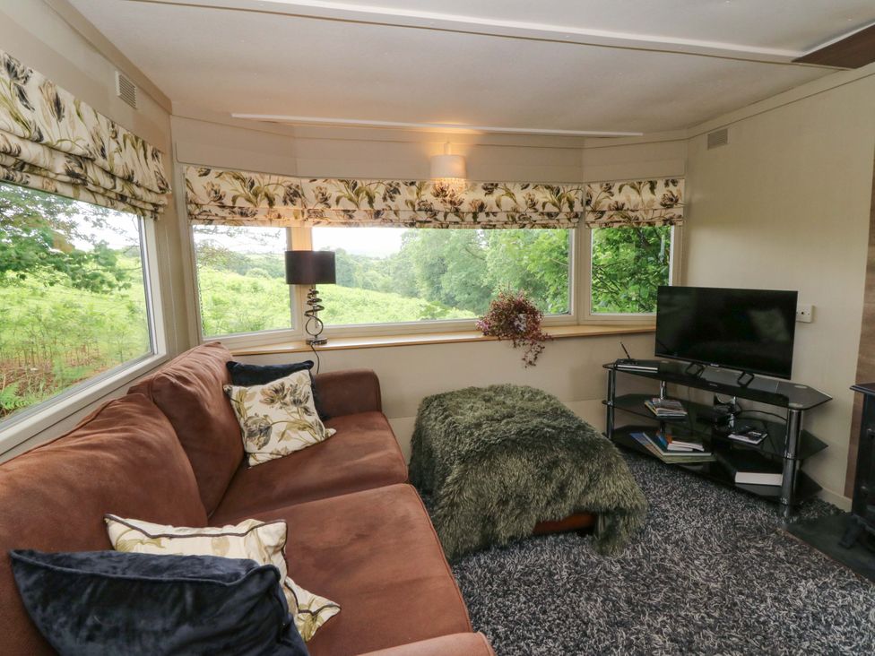 A snug with a sofa and television at Gwybedog in Llanwrda