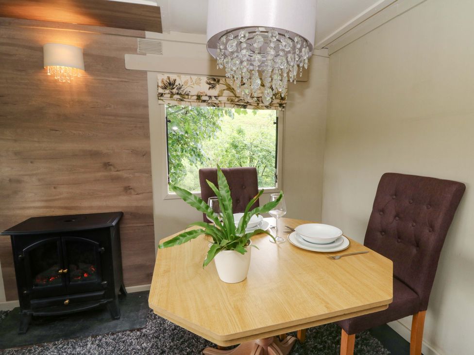 A dining room with a table and chairs at Gwybedog in Llanwrda