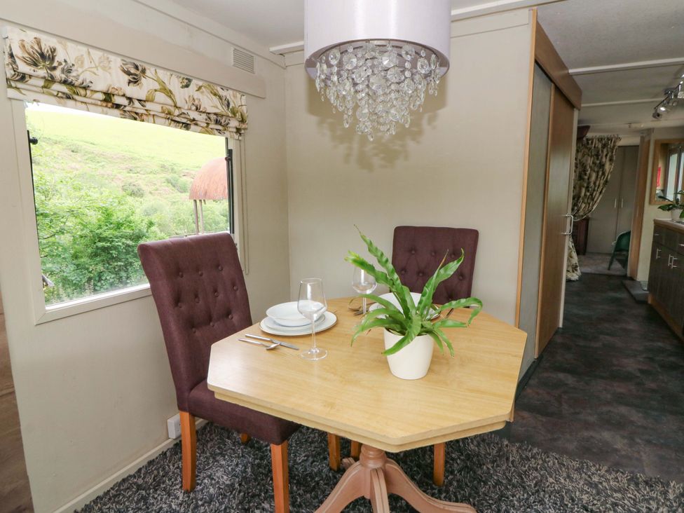 A dining room with a table and two chairs at Gwybedog in Llanwrda