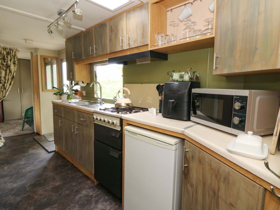 A kitchen with cabinets and appliances at Gwybedog Llanwrda