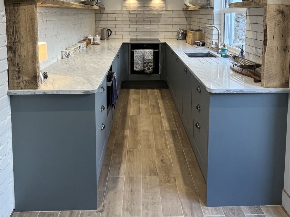 A kitchen with countertops, sink, kettle, and utensils at 21 Station Hill