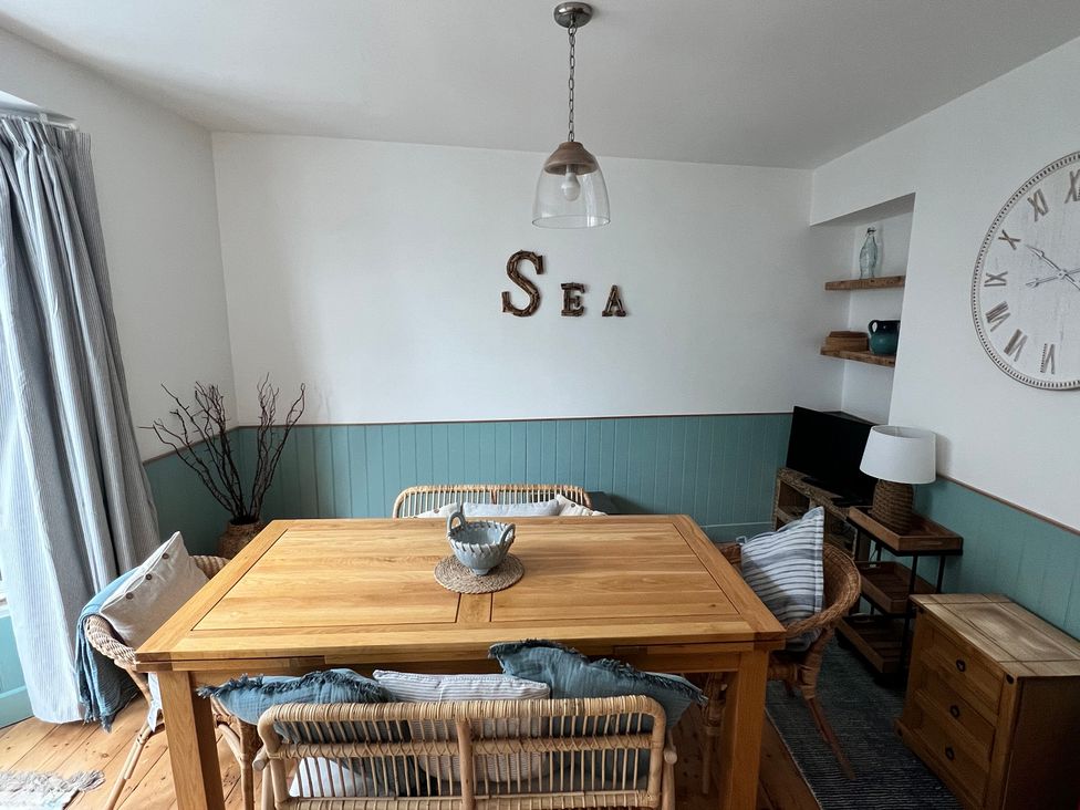 A dining room with a table and chairs at Still Waters in Brixham