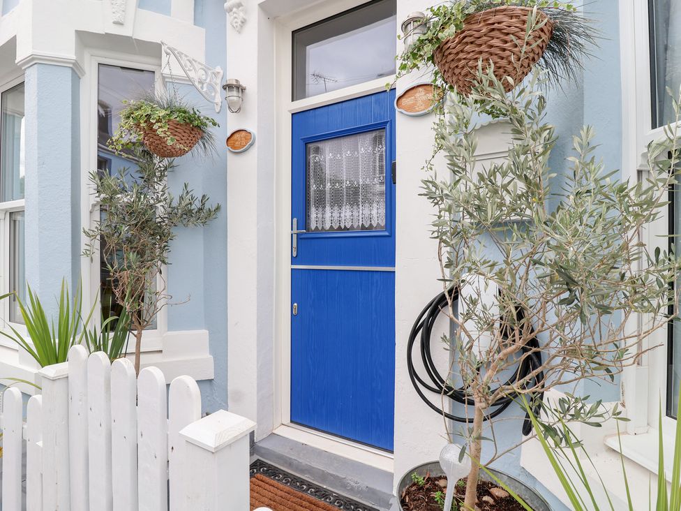 An entryway with a blue door and potted plants at Still Waters in Brixham
