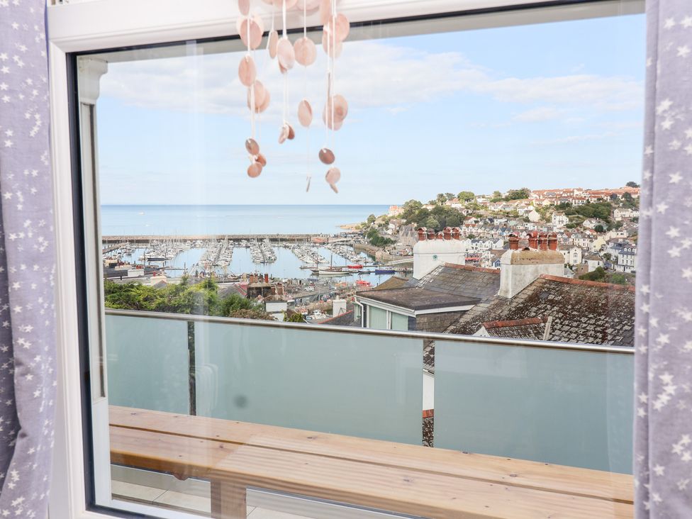 A view from a window overlooking a marina and coastal houses at Still Waters in Brixham